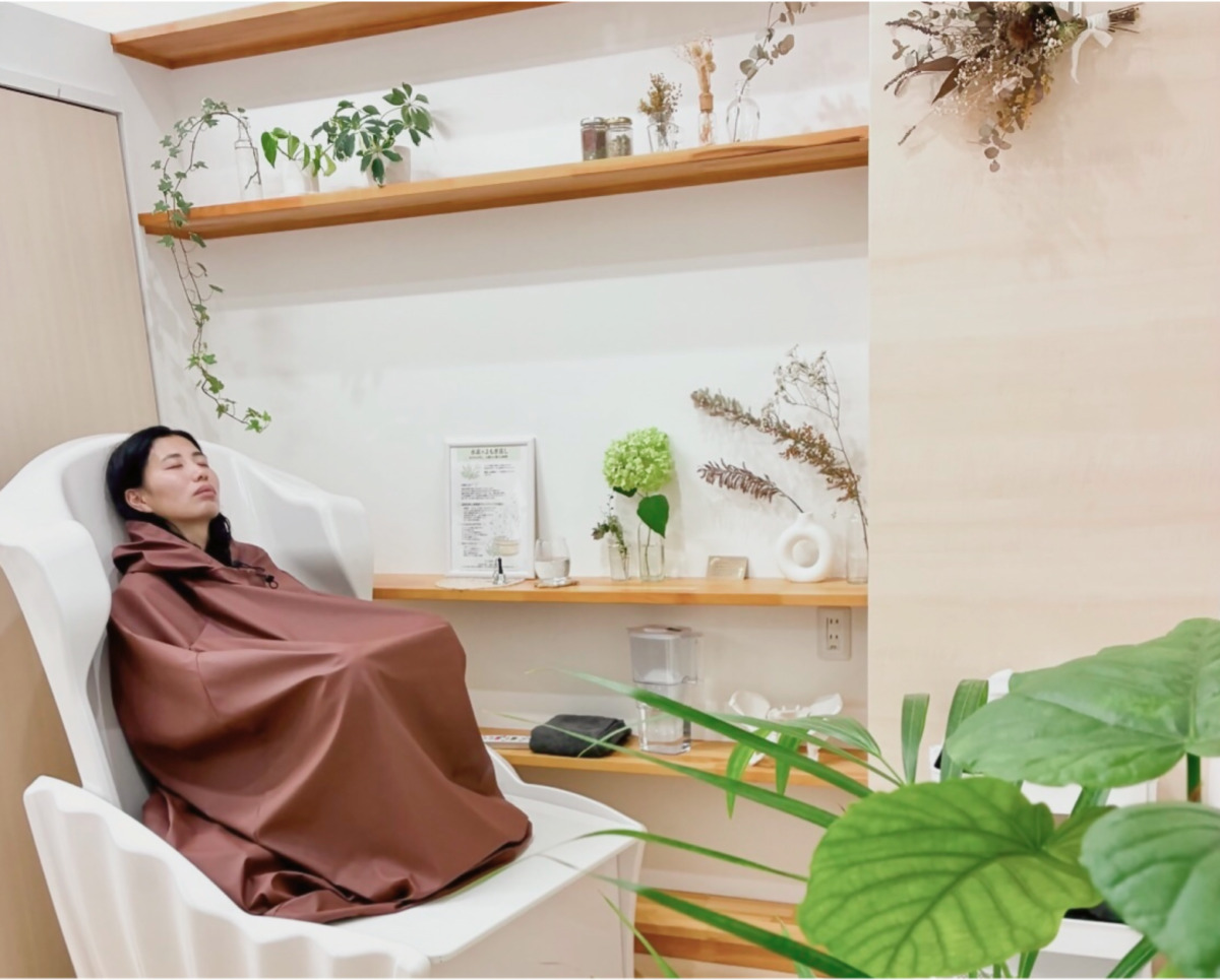 水素よもぎ蒸しを受けている女性と、植物に囲まれたサロンの店内